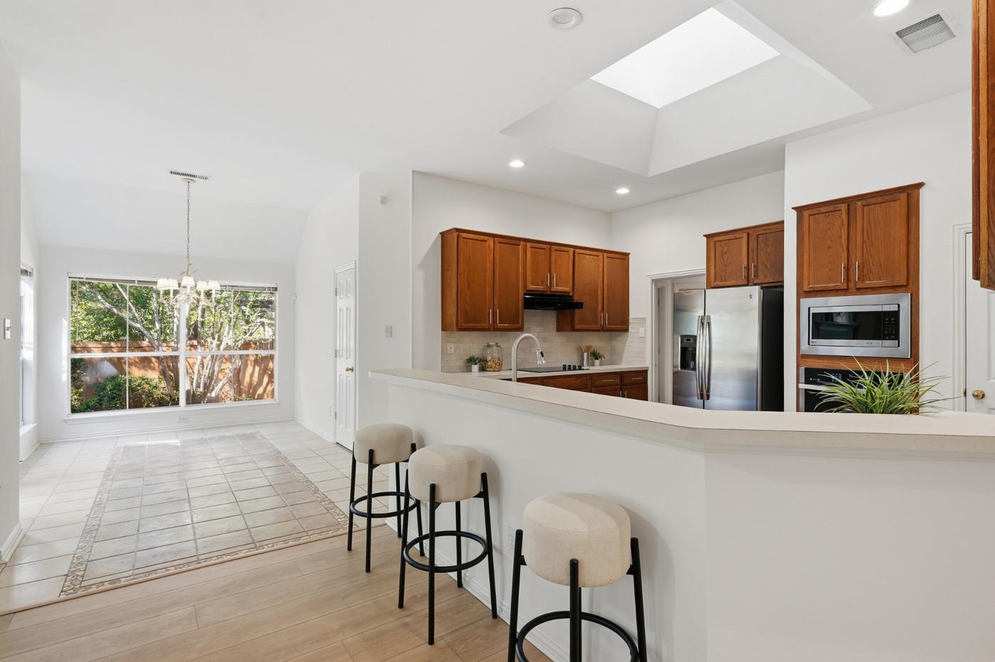 Kitchen with skylight, breakfast bar, and stainless refrigerator